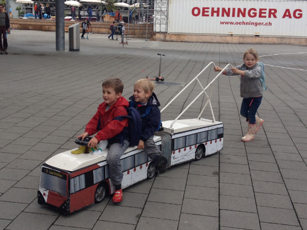 Kinder spielen mit einem Trolleybusmodell im Verkehrshaus Luzern auf einem Ausflug mit der Kinderkrippe Stärnschnuppe