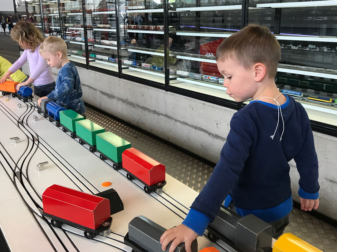 Kinder spielen mit Zügen im Verkehrshaus Luzern auf einem Ausflug mit der Kinderkrippe Stärnschnuppe