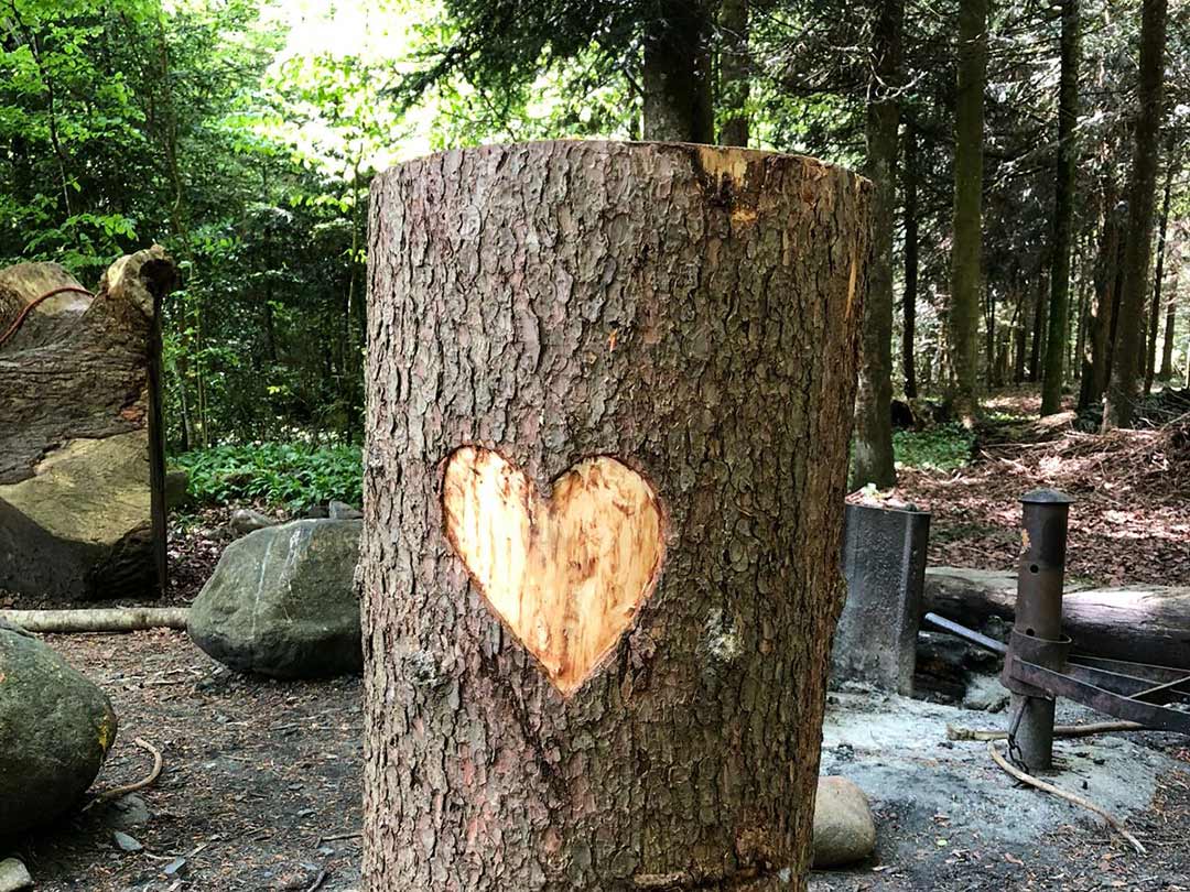 Mit Herz verzierter Baumstamm auf den Picknickplatz der Waldgruppe der Kinderkrippe Stärnschnuppe