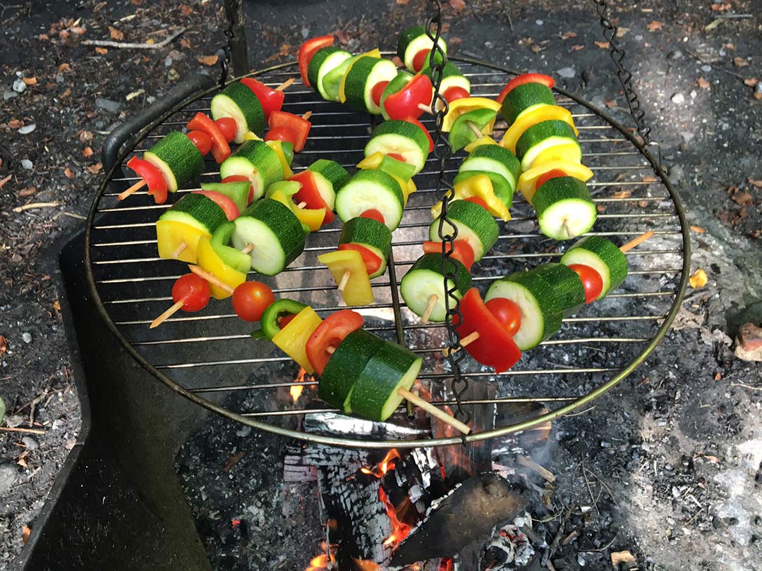 Gemüsespiesse werden auf dem Feuer im Wald für die Kinder der Waldgruppe der Kinderkrippe Stärnschnuppe zubereitet